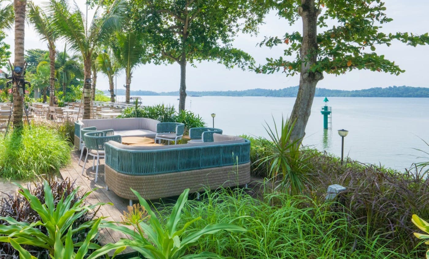 Rattan daybeds on the lawn overlooking the water