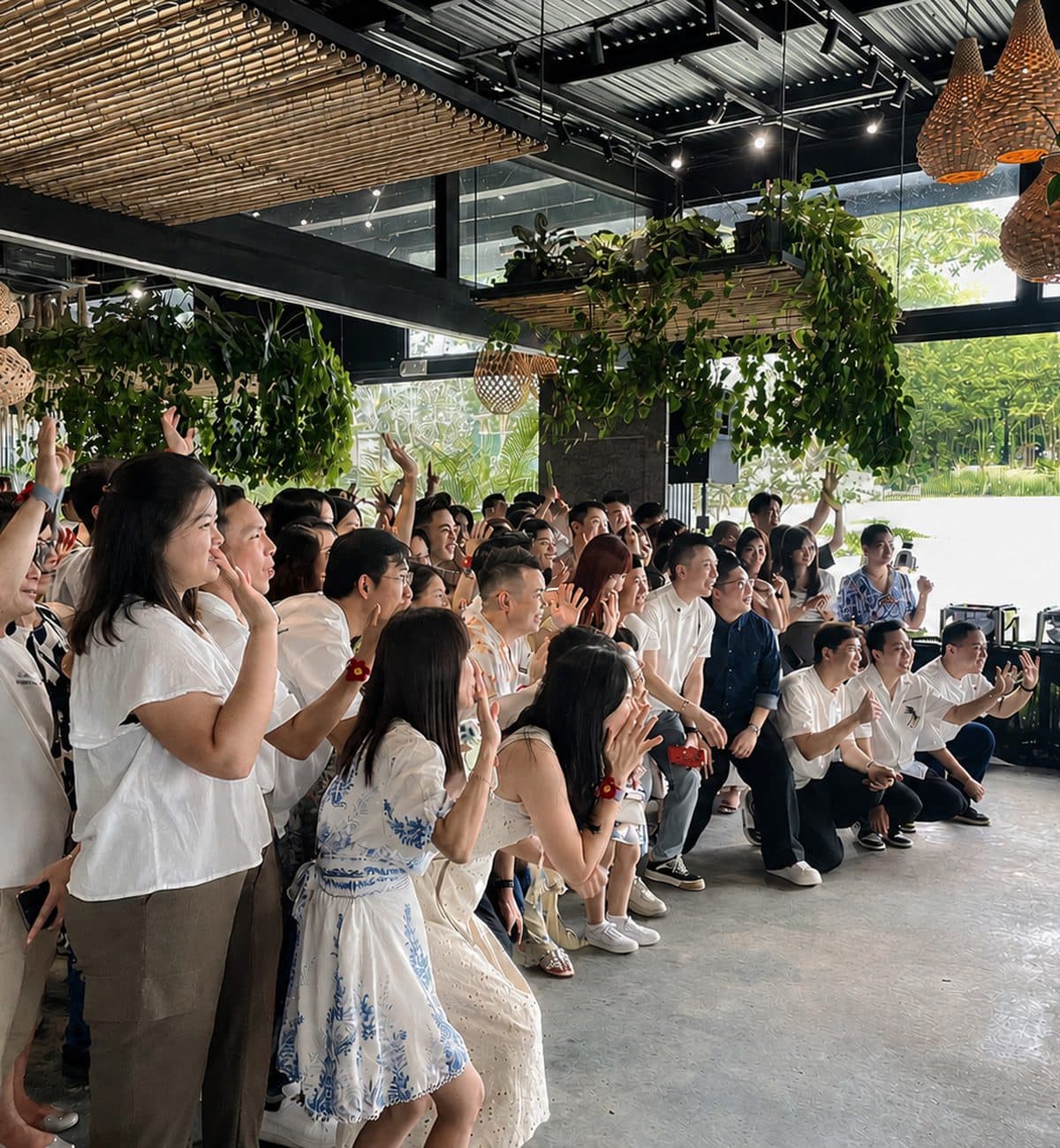 A company group applauding at Canopy HortPark under the planted ceiling