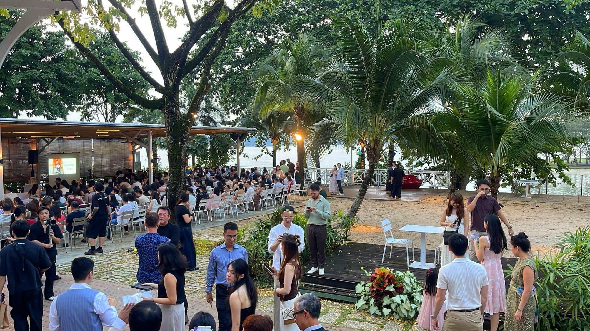 A celebration at dusk under the trees at Canopy Changi Village, the water beyond