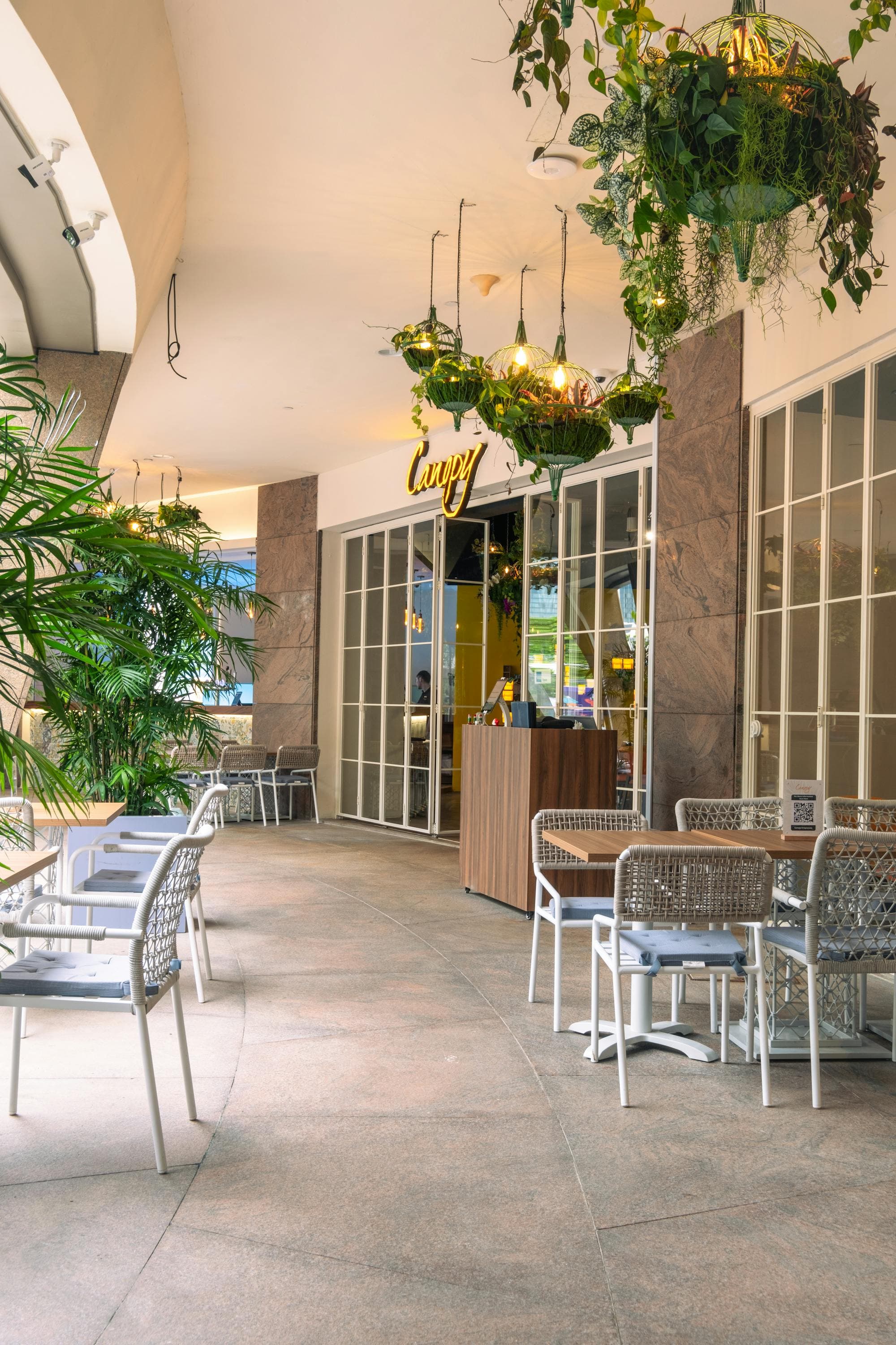 The sheltered alfresco walkway at Canopy Esplanade, plants hanging overhead