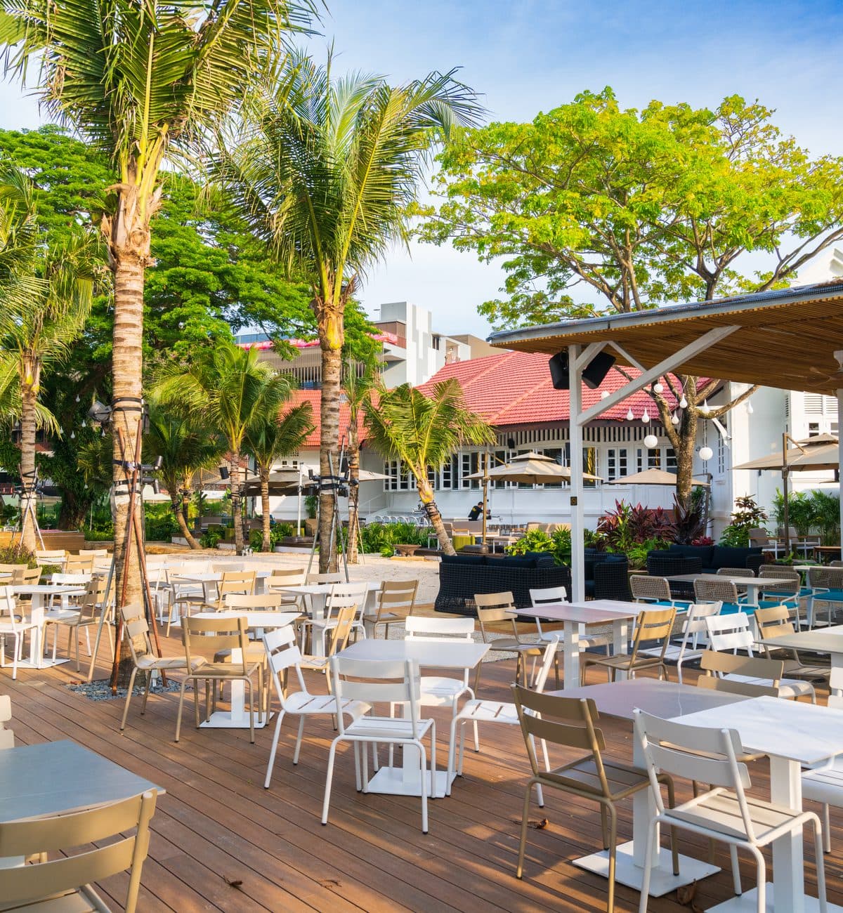 The timber deck at Canopy Changi Village, white tables under the palms