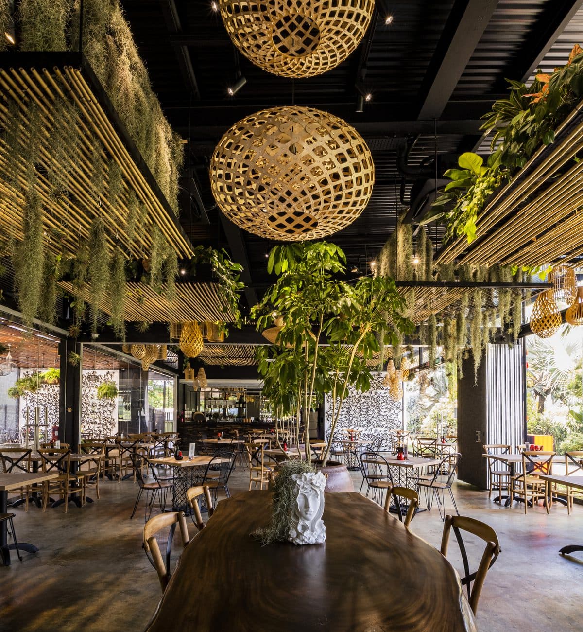 The dining room at Canopy HortPark from the far end, rattan spheres and bamboo slats over the tables