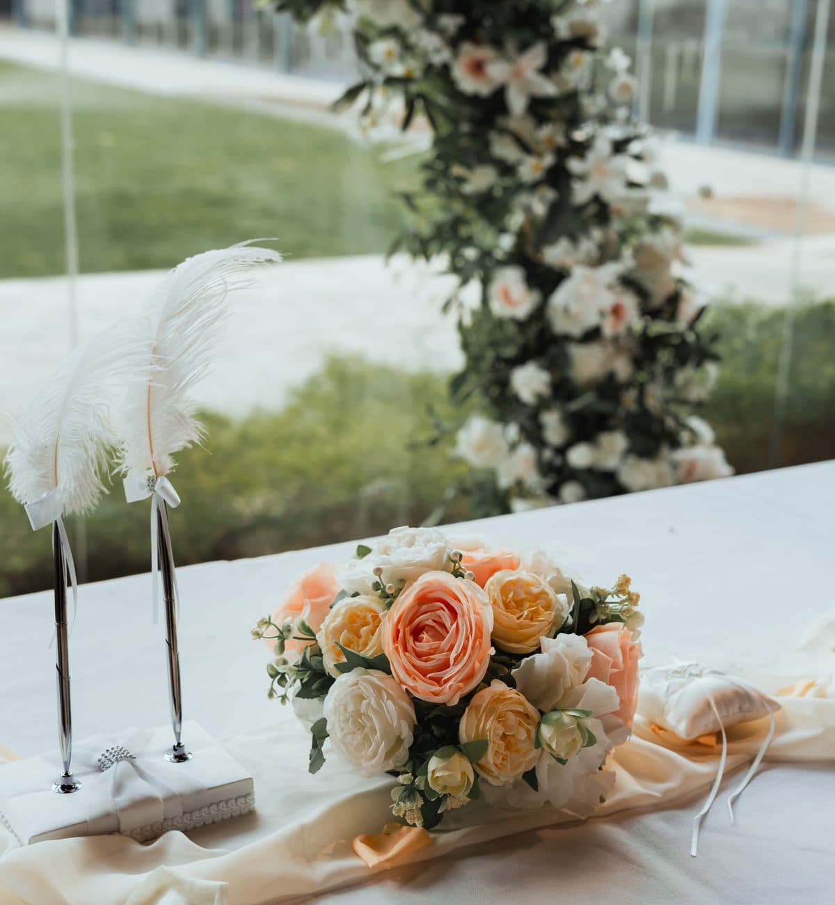 The signing table at Canopy HortPark: bouquet, feather pens and the ring cushion
