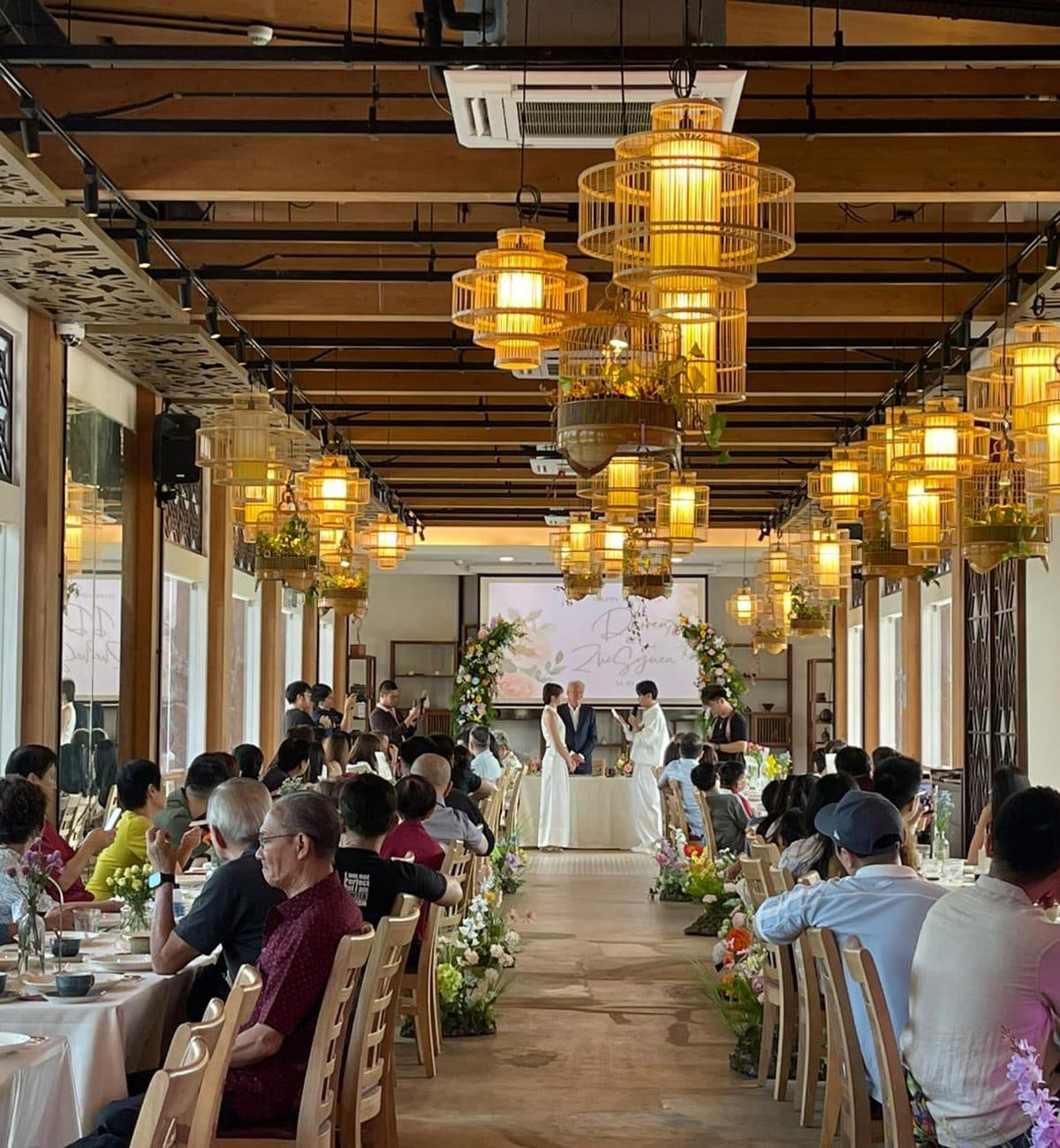 A solemnisation under the timber pavilion at Canopy Jurong Lake Gardens, birdcage lanterns overhead