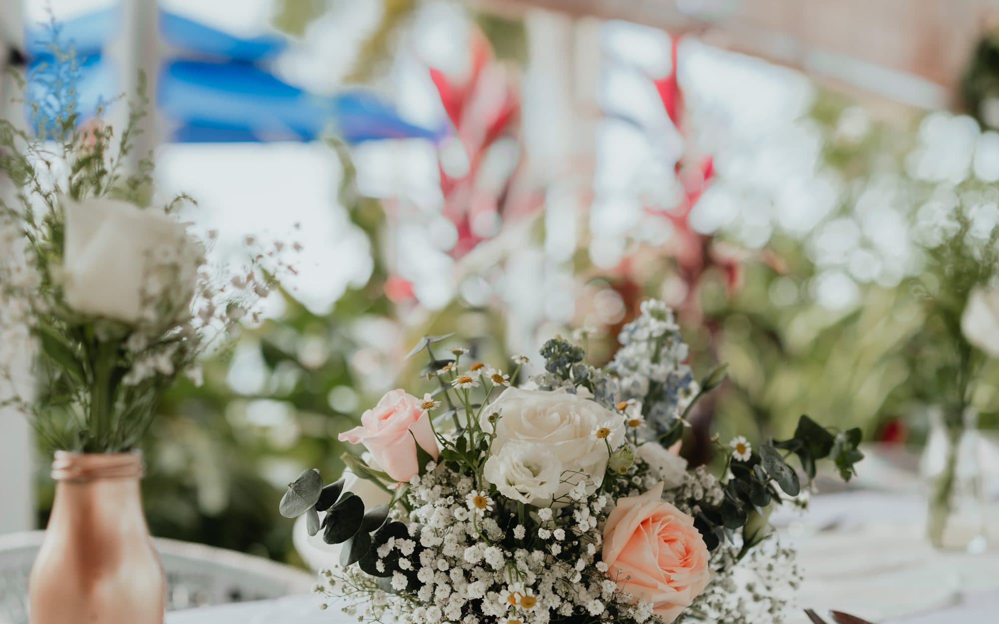 Peach and white table florals in a copper bottle at a Canopy Changi Village reception