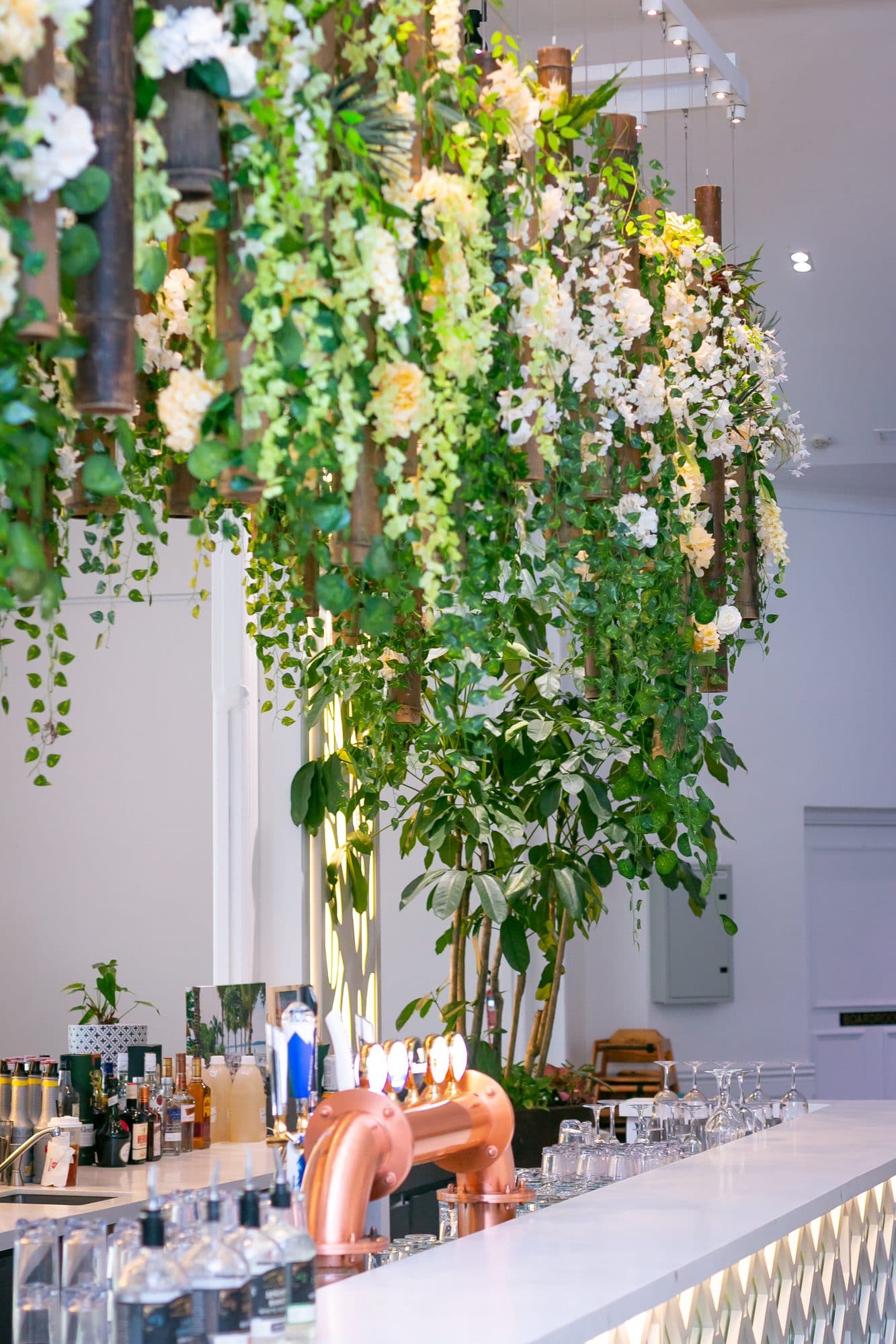 The bar at Canopy Changi Village under a tall floral installation