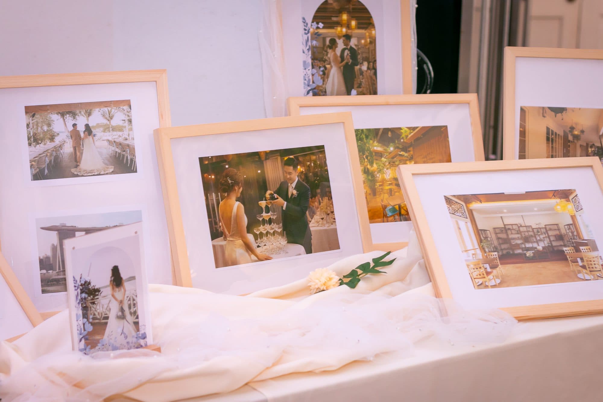 Framed wedding photographs displayed on a draped table at the showcase