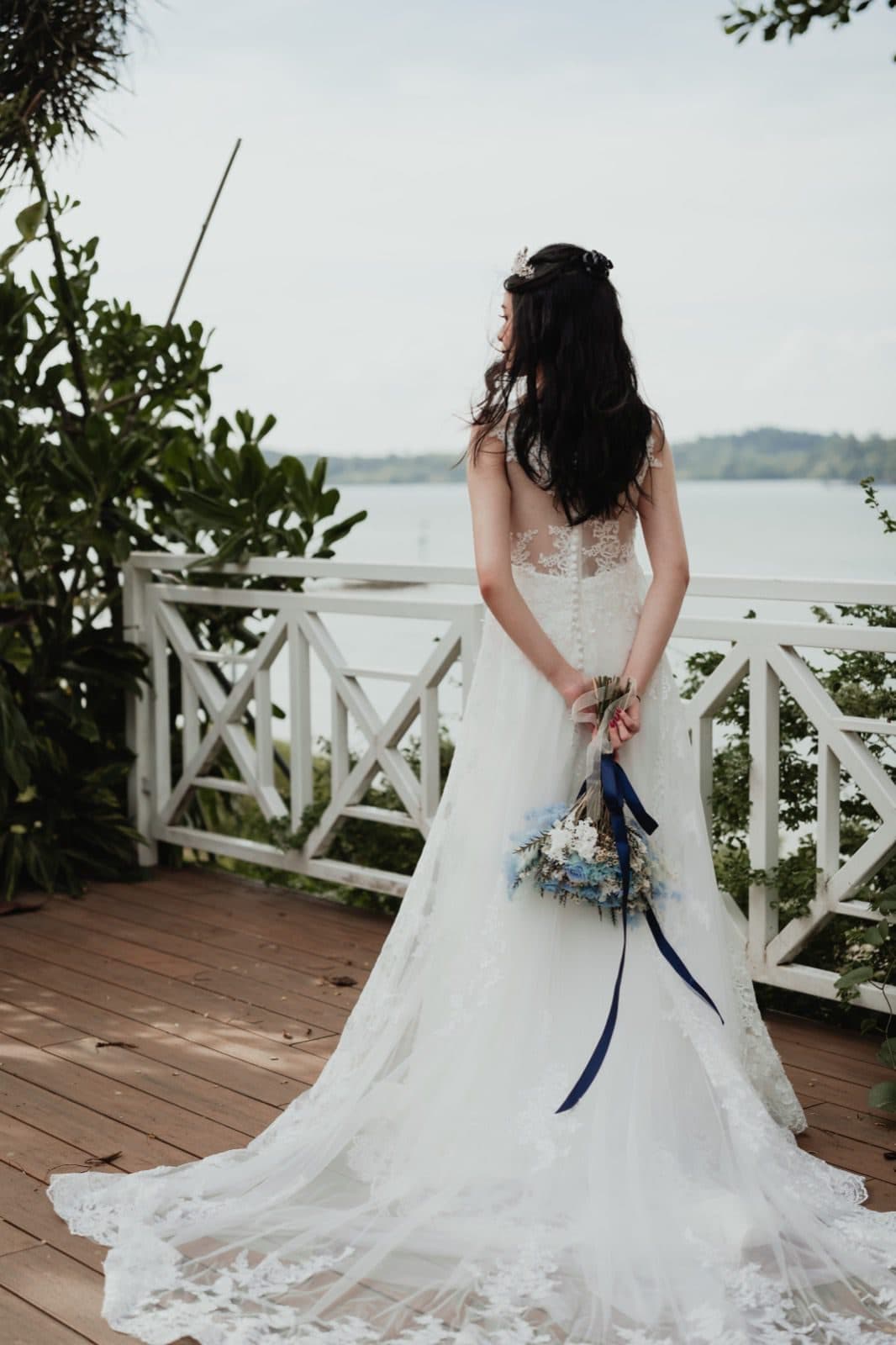 A bride on the timber deck at Canopy Changi Village, the water beyond