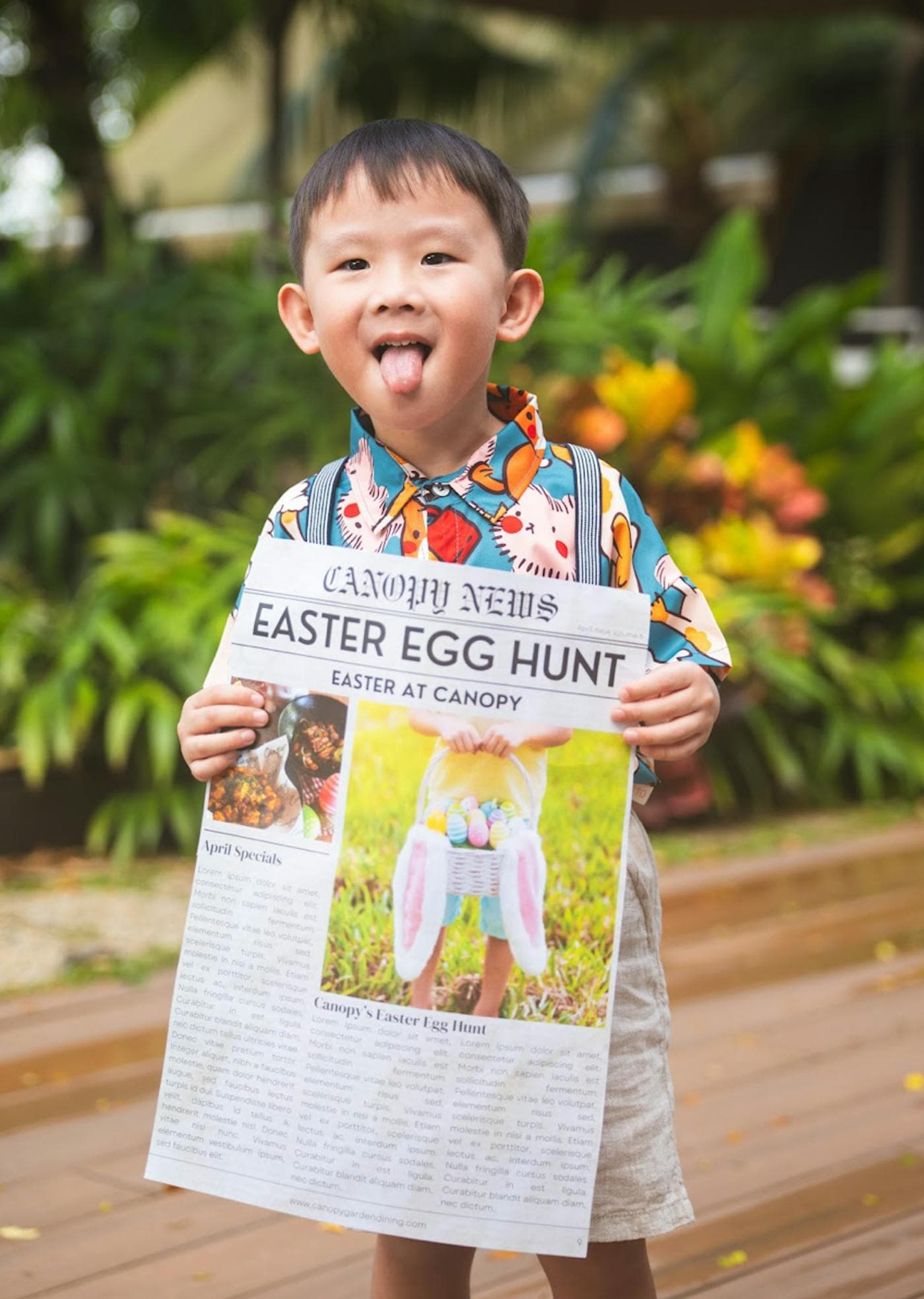 A boy holding up a Canopy News front page announcing the Easter egg hunt