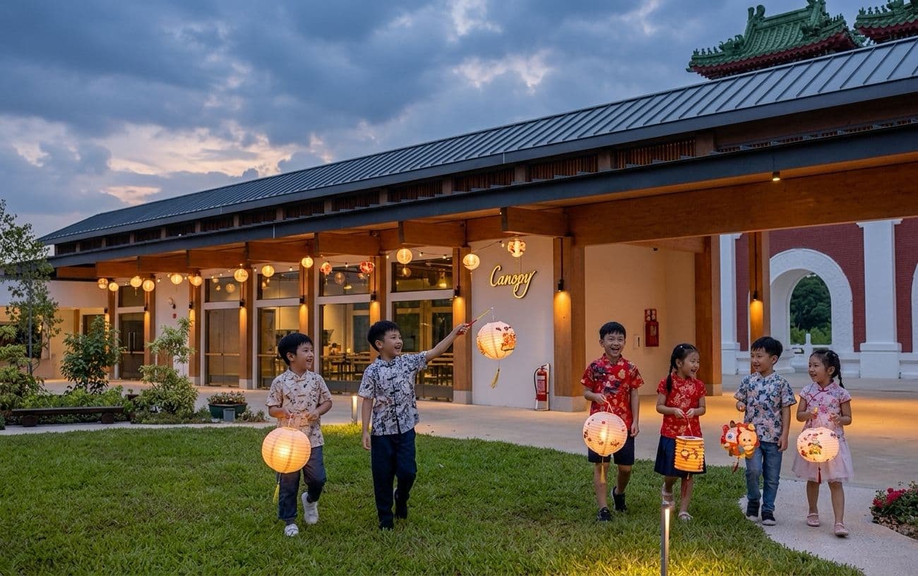 Children carrying paper lanterns on the lawn outside the pavilion at dusk